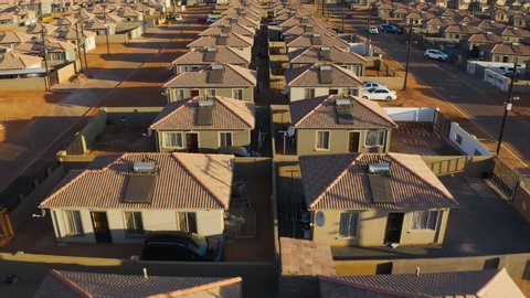 Aerial close-up fly over view of low cost housing in an African township with solar geysers on the rooftops, South Africa
