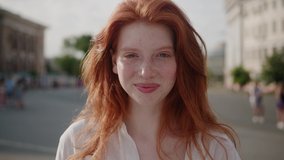 Face young sunshine woman with red hair look at camera smile stand in the city streets summer beautiful lady portrait happy outdoor close up slow motion - Powered by Shutterstock - Get 15% off with code: PIKWIZARD15
