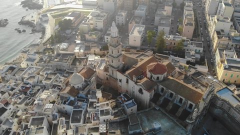 Italian city by the sea at a sunny day. Aerial view of the church, houses, and the sea. Monopoli, Puglia, Bari, Italy in 4K