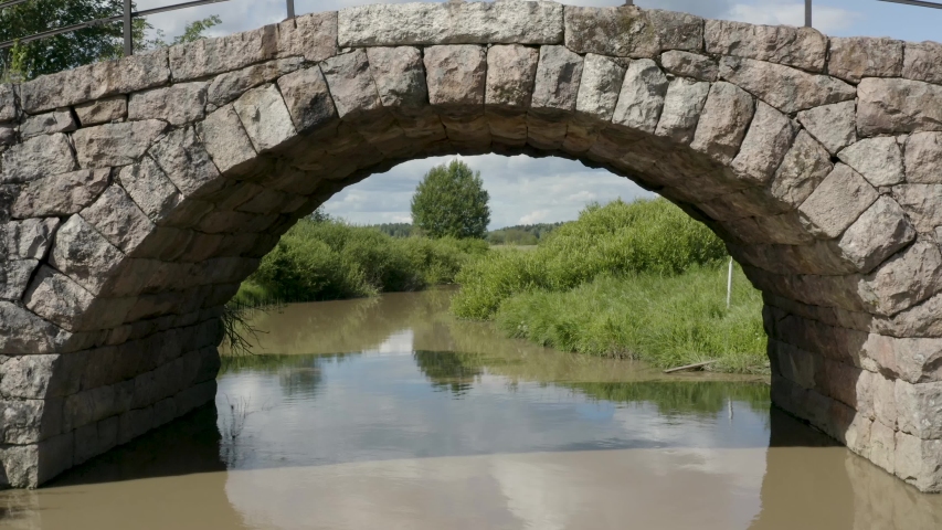 Slow aerial fly through of an old stone bridge in Finland near Kerava.