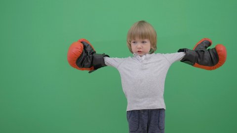 Little child with red gloves prepare for fight, green screen