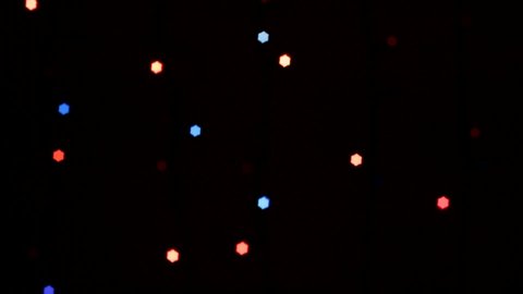 
multicolored lights garland out of focus on dark background, christmas background