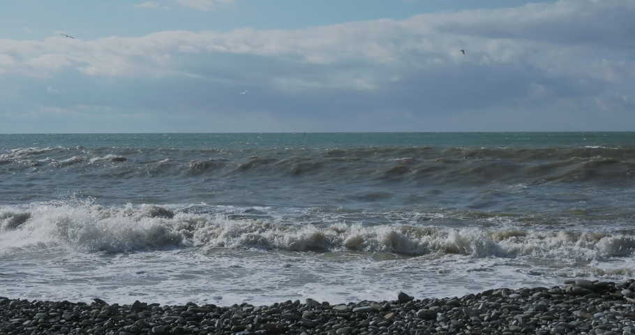 Sea surf on rocky beach. Tranquil natural background at sunny day. Black sea, Sochi, Russia. | Shutterstock HD Video #1057254511