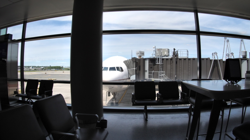 Empty boarding area. Dolly POV push in on an airplane outside the window. No travelers at the airport during early days of COVID-19 pandemic Royalty-Free Stock Footage #1057254658