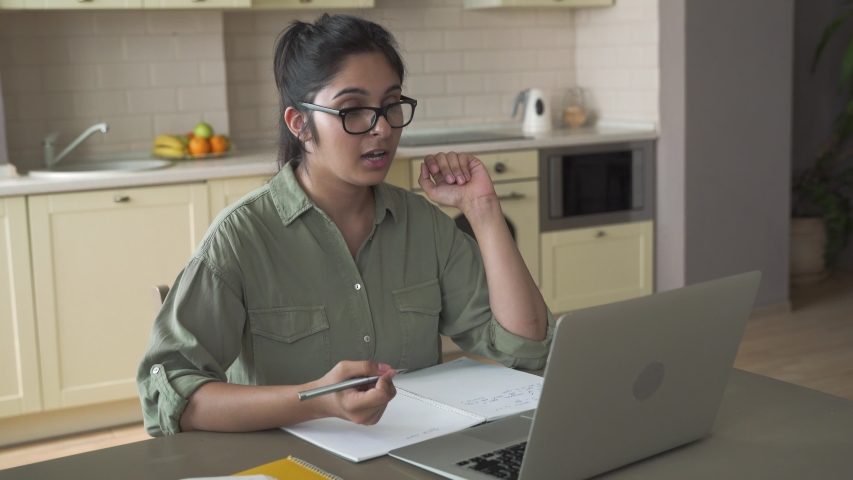 Indian woman online tutor remote teacher wearing glasses speaking to webcam chat explaining remote course video call school lesson looking at laptop virtual conference meeting work at home office. Royalty-Free Stock Footage #1057255072