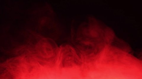 Red smoke spreads like fog. Texture of cigarette white smoke on a black background. Slow motion.