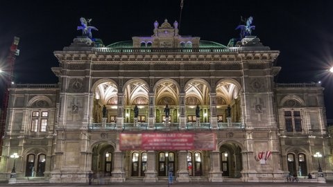 Beautiful view of Wiener Staatsoper (Vienna State Opera) night timelapse hyperlapse in Vienna, Austria. Illuminated historic buildings and traffic on streets