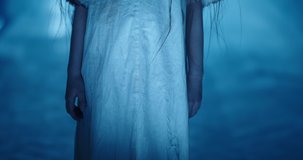 Girl in little white sundress creepily staring into camera, dressed for halloween. Child's ghost in haunted house - halloween costume party 4k footage