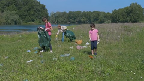 Family pick up garbage. A family for eco life collect the plastic trash from the field into the bags.