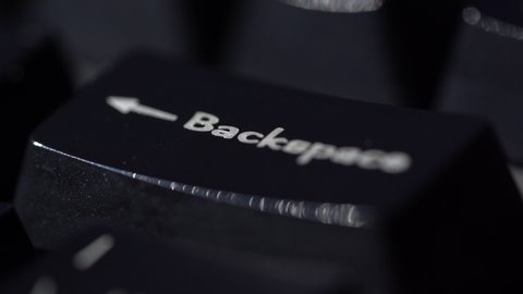 Macro view of Human finger pressing a Backspace key on the computer keyboard