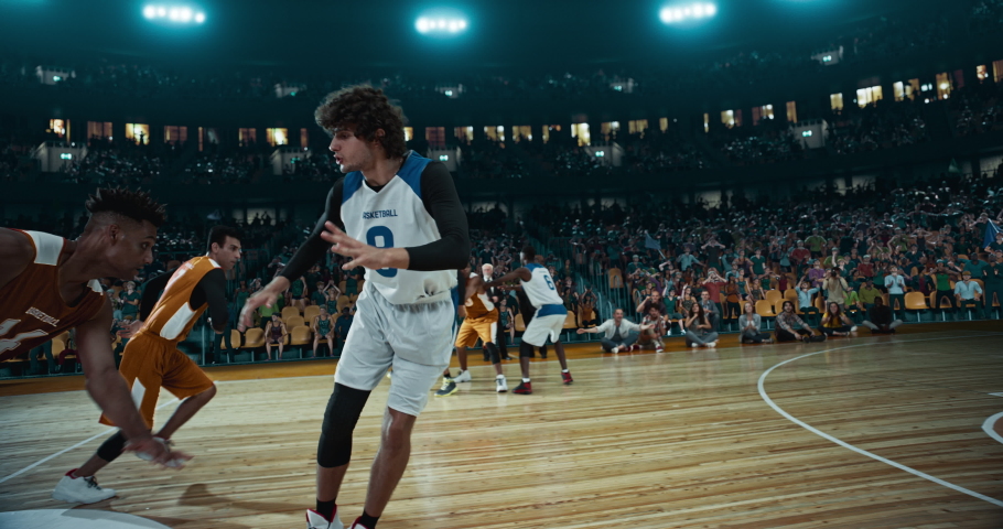 Basketball player scores a goal on a professional basketball stadium. Stadium is made in 3d with animated crowd. Dynamic shot. | Shutterstock HD Video #1057289005