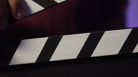 Clapboard on set. Director says action! and the clapboard close down. Cinema or photoshoot concept. Hollywood set with blue background. Close up shot