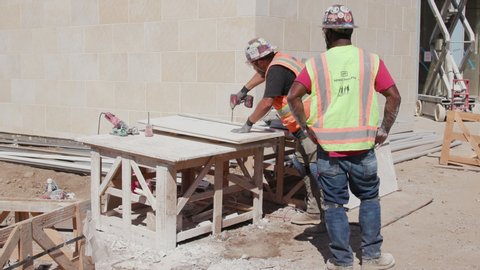 San Diego, California / USA - October 7, 2019: Stonemasons cutting and preparing limestone for installation.