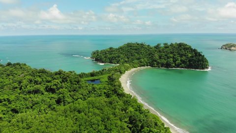 Aerial shot of tropical forest of National Park Manuel Antonio and Cathedral Point, Costa Rica. Sunny weather, clear blue green water.