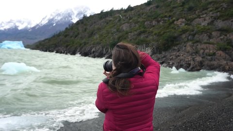 Torres Del Paine, Chilean Andes. Slow Motion of Female Photographer Taking Picture of Icebergs in Lago de Grey, Patagonia