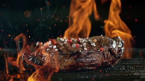 Tasty beef steak on iron cast grate, super slow motion, filmed on high speed cinematic camera at 1000 fps.