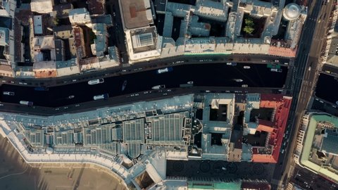 Saint Petersburg buildings roofs shot from above, drone aerial shot. Top view of european buildings in sunny day, fly over canal with boats and roads with cars in european city