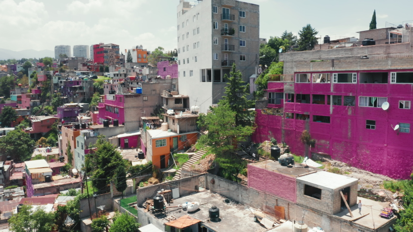 Famous Mexico city destination site with pink favelas on the green hillside. Vibrant Mexico city suburban district. Traveling Central America, exploring Mexico city. Low-income buildings 4K aerial Royalty-Free Stock Footage #1057300726