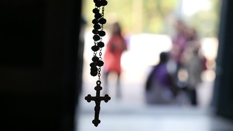 Silhouette of a rosary necklace with blurred background   