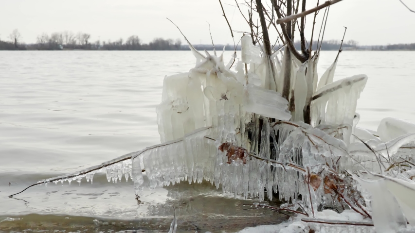 Low shot of lake with frozen shore with Ice