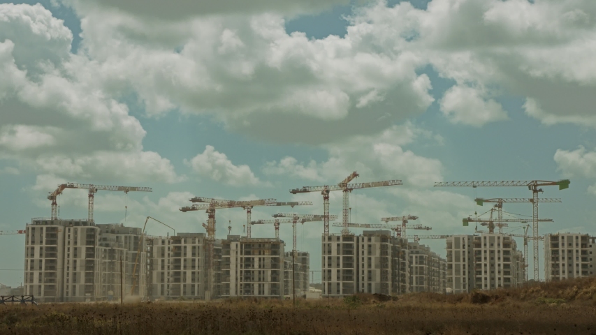 Timelapse of a large construction site with many cranes working over buildings Royalty-Free Stock Footage #1057308772