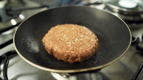 Tempering vegan plant based burger cooking on frying pan