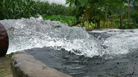 Water flow treatment system from the water pump pipe.Slow motion of water gushing out of the pipe from Koi Pond Carp fish farm for oxygen