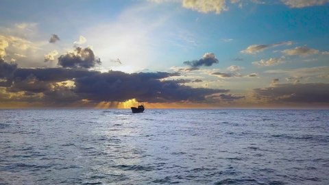 Flight over the sea and ship aground. Cargo vessel Demetrios II shipwrecked near rocky coast in Mediterranean sea at Paphos, Cyprus. Beautiful sunset and clouds over the sea. 4K