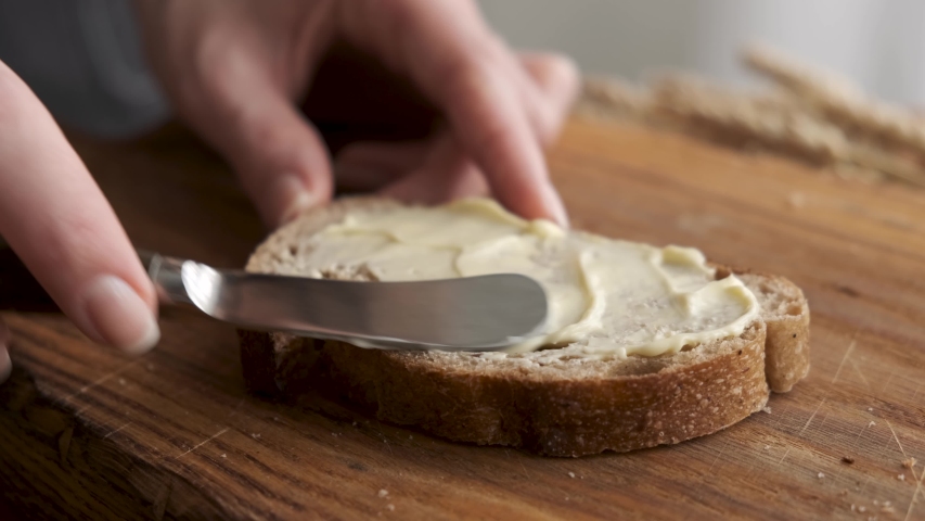Smear organic butter on bread. Soft butter spreading on slice of sourdough bread. Carbohydrates, fat concept Royalty-Free Stock Footage #1057331830