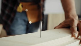Detail video of carpenter using a hammer to drive nail. Shot with RED helium camera in 8K