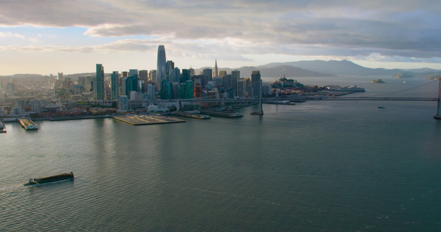 Aerial view of San Francisco skyline. Famous skyscrapers over a blue sky. Oakland Bay Bridge. California, United States. Shot on Red weapon 8K.