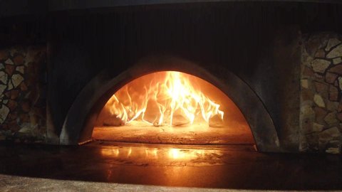 Fire wood burning in the oven. Italian pizzeria. Traditional Pizza oven. Authentic Italian oven. It was built by hand from Naples earth. The original pizza oven with flame  inside.