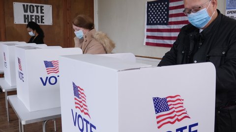 4K: Voters voting at Polling Place for USA Election.  Diverse People Stood at booths wearing Face Masks. Gimbal movement Up. Stock Video Clip Footage