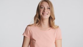 Attractive emotional blond girl happily laughing on camera over white background