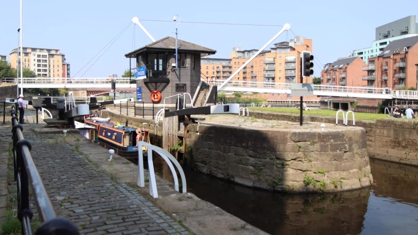 Leeds UK 12th Aug 2020: Footage of the  canal locks gates in the Leeds & Liverpool canal showing water barges  boat homes going through the gates in the summer time at the Leeds Dock area of the city