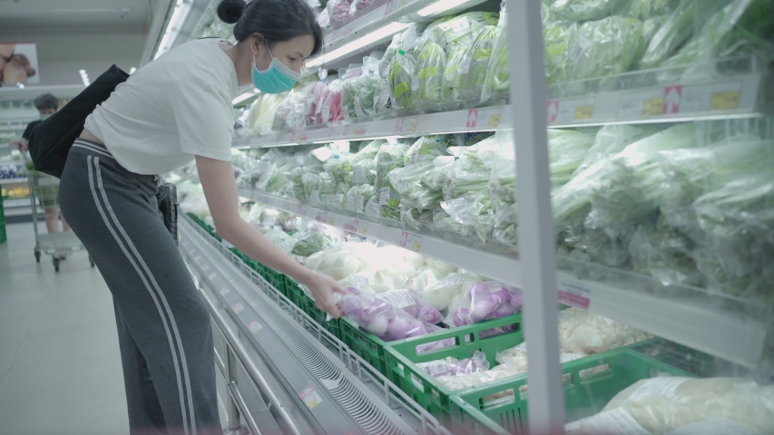 4k Young Asian woman Getting food at grocery store looking at vegetables shelf, supermarket chain, stock up food supply, during covid19 lockdown  corona virus pandemic, female wearing medical mask Royalty-Free Stock Footage #1057353187