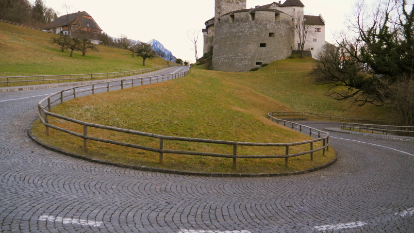 Vaduz Castle Liechtenstein clear sunny winter day. Wide angle view, hillside and green grass. Pedestal up shot.