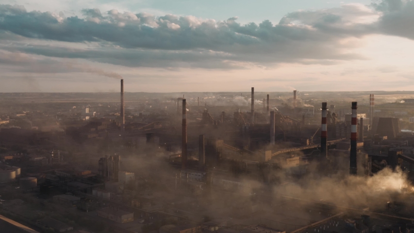 Drone shot of industrial zone with thick smog and burning fossil fuels. Zoom in aerial shot of factory zone shot from top, air pollution and soot in many factory chimneys in city area Royalty-Free Stock Footage #1057361683