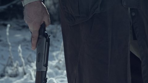 Close up of a man reloading old 30-30 winchester rifle, snowy background