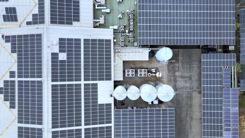 Drone aerial shot 4k. Solar panels on roof of modern factory industrial warehouse. Generating clean renewable electric energy. Solar energy on sunny day.  