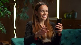 Happy businesswoman talking on smartphone by video chat at home office. Excited woman using phone for video call in office interior. Smiling business woman gesturing at cellphone camera - Powered by Shutterstock - Get 15% off with code: PIKWIZARD15