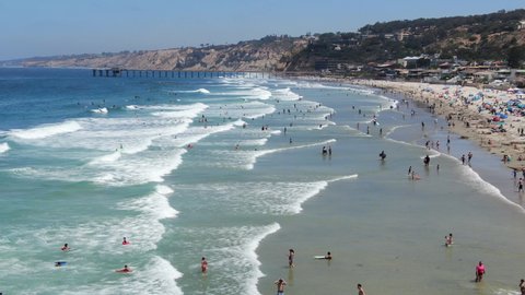 Aerial view of tourists and families enjoying the beach and small waves during summer day in La Jolla, San Diego, California, USA. Beach with pacific ocean.
