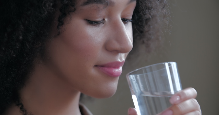 Young dehydrated adult woman holding glass in hand drinking fresh pure mineral clear water enjoying taste. Thirsty healthy lady hydrating thirst keeping fluid body care balance concept. Close up view Royalty-Free Stock Footage #1057372933