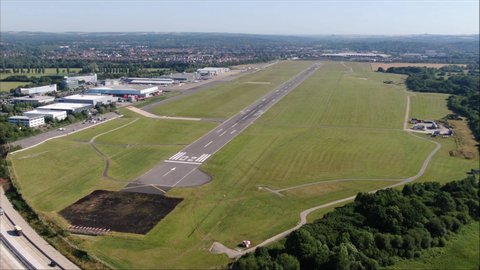 Southampton International Airport Runway aerial orbit drone shot. UK flights, transportation. COVID-19 means lack of flights, quiet. Flybe job losses.Motorway, M27