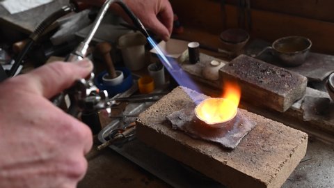adult jeweler melts gold in a liquid state in a crucible. Craft luxury jewelery 