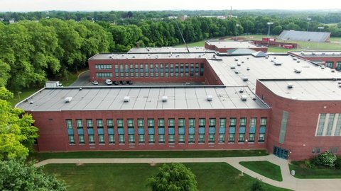 Aerial truck shot of large public school building in United States, closed due to COVID-19, coronavirus pandemic in USA