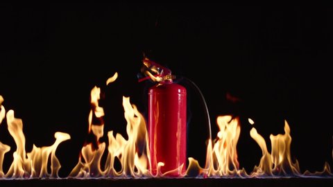 Fire extinguisher burning on black background .  Fire extinguisher and flames . Shot on ARRI ALEXA Cinema Camera in slow motion 200fps .