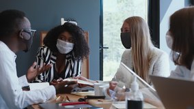 Happy multiethnic creative start-up business people talk at meeting at light modern office table wearing face masks. - Powered by Shutterstock - Get 15% off with code: PIKWIZARD15