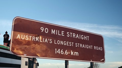 Slow dolly shot of 90 Mile Straight, Austalians longest straight road 146,6 km sign