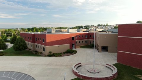 Aerial of new brick expensive modern school building standing empty in United States, COVID coronavirus cancels schools in America